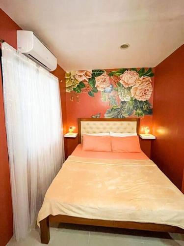 a bedroom with a bed with a painting of roses at Townhouse with game area and access to swimming pool in San Fernando