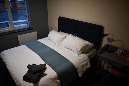 a bedroom with a large bed with a black headboard at The Bridge Inn in Tenbury