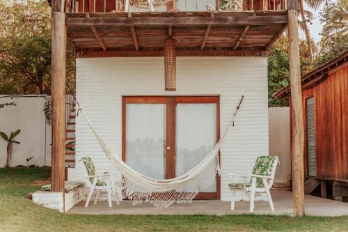 a hammock on the porch of a house at Casa na Lagoa in Paracuru