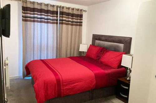 a bedroom with a red bed with a red blanket at Superb Apartment CR0 in Croydon