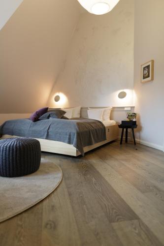 a bedroom with a bed and a wooden floor at Hotel Aarnhoog in Keitum