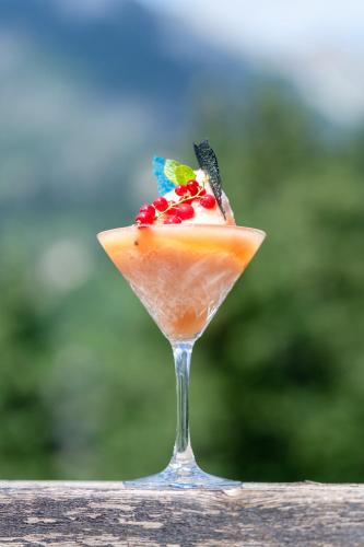 a drink in a glass sitting on a table at Hotel Fanes Suite & Spa in Moena