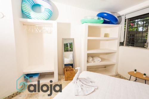 1 dormitorio con estantes blancos y espejo en Villa Xtohil with private access to the magic 7 colors lagoon, en Bacalar