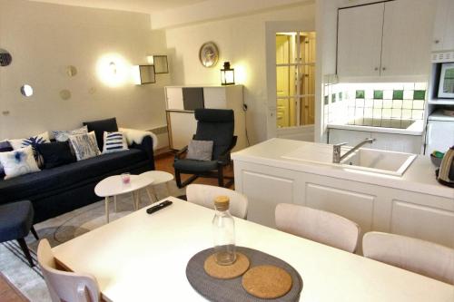 une cuisine et un salon avec une table et un canapé dans l'établissement Nice 55m in residence with pool and garden !, à Moliets-et-Maa