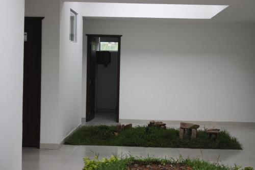 a white house with a garden in front of it at Hotel Las Piedras San Jose in San José de Isnos