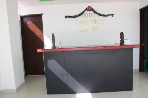 a counter in a room with a sign on the wall at Hotel Las Piedras San Jose in San José de Isnos
