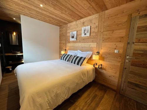 a bedroom with a bed and a wooden wall at Appartement les Clochettes 1 - Pied des pistes in Les Deux Alpes