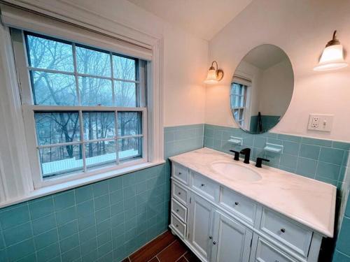 a bathroom with a sink and a mirror and a window at Phillips Academy Andover Two-Bedroom Apartment and Free Parking in Andover