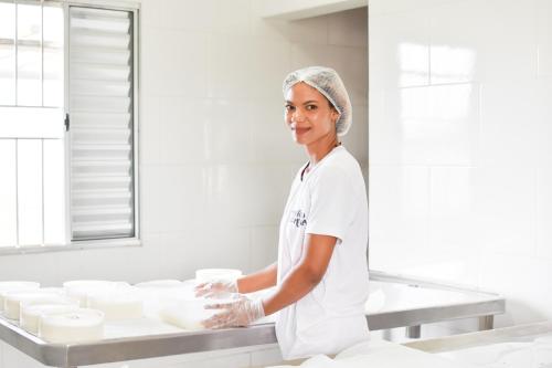 a woman standing in a kitchen preparing food at Bubble Pingo do Mula Serra da Canastra in São Roque de Minas