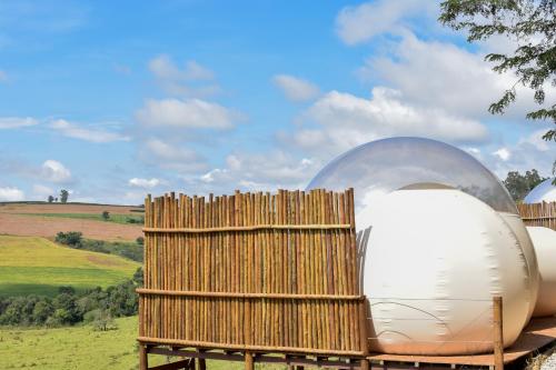 a building with a glass dome and a wooden fence at Bubble Pingo do Mula Serra da Canastra in São Roque de Minas