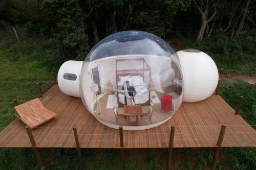 a man is standing inside of a round house at Bubble Pingo do Mula Serra da Canastra in São Roque de Minas