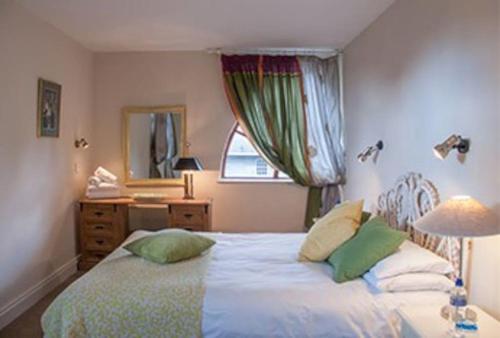 a bedroom with a bed and a dresser and a mirror at Loughcrew House in Oldcastle