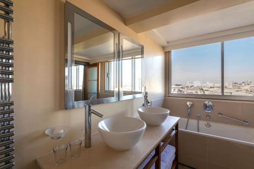 two sinks in a bathroom with a large window at The Cavendish London in London