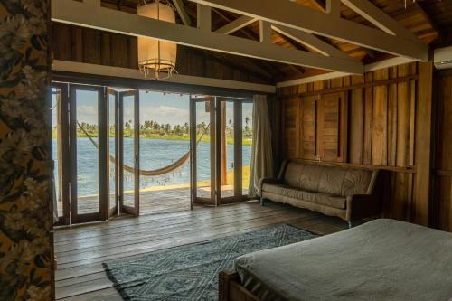um quarto com uma cama e vista para a água em Casa na Lagoa em Paracuru