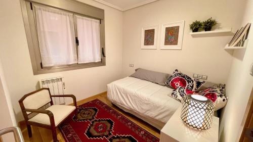 1 dormitorio pequeño con 1 cama y 1 silla en The Cliffs - Ortigueira Kalmak, en Santa Marta de Ortigueira