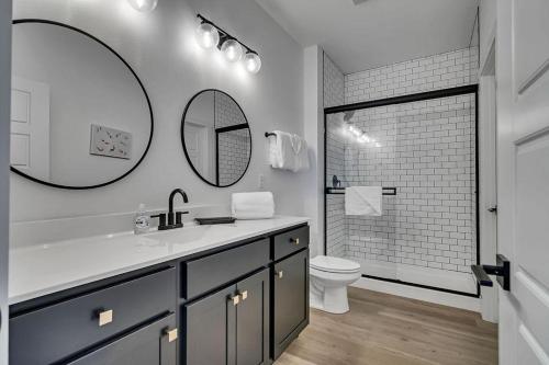 a bathroom with a sink and a toilet and a mirror at Modern Rustic in Branson