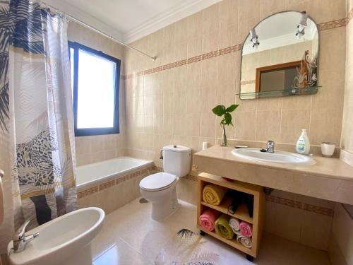a bathroom with a sink and a toilet and a mirror at Casa Inma Las Piteras. Sol y agua in Costa Teguise