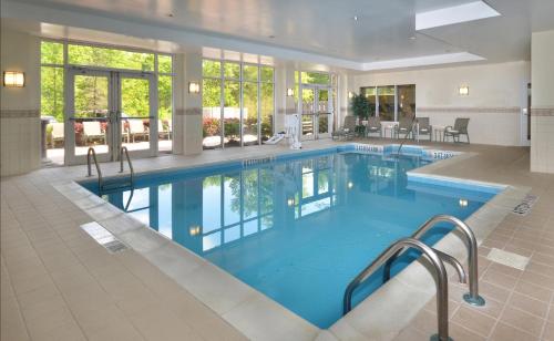 a large swimming pool with blue water in a building at Holiday Inn Raleigh Durham Airport by IHG in Morrisville