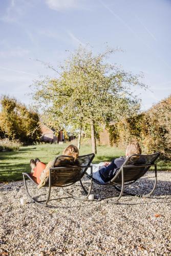 two people sitting in lawn chairs in a park at Viktoria Guesthouse in Westerlo