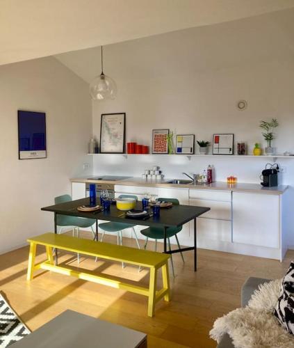 un salon avec une table et une cuisine dans l'établissement Charmant Appartement Pop - Arty, à Thonon-les-Bains