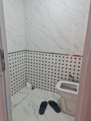 a bathroom with a toilet and a pair of slippers at BYCOACH TRAVEL APARTMENT in Istanbul