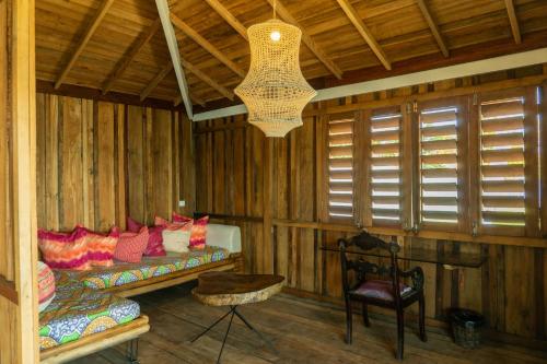 a room with a couch and a chair and a chandelier at Casa na Lagoa in Paracuru