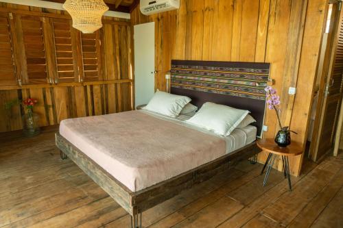 a bedroom with a large bed with wooden walls at Casa na Lagoa in Paracuru