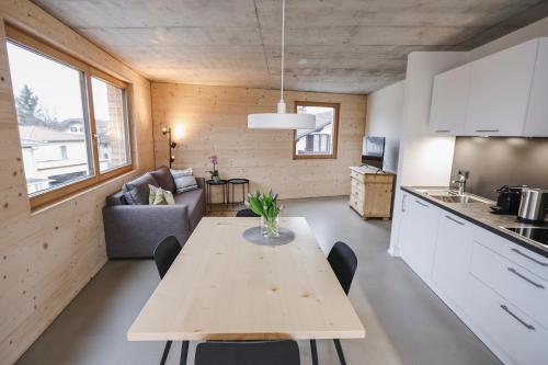 uma cozinha e sala de estar com uma mesa num quarto em BOUTIQUE APARTMENTS LUSTENAU Nachhaltige Kühlung über Erdsonde und Fussbodenkühlung em Lustenau