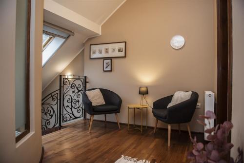 a living room with two chairs and a window at Hilltop Wellness Villa-big garden, sauna, hot tube in Pécs