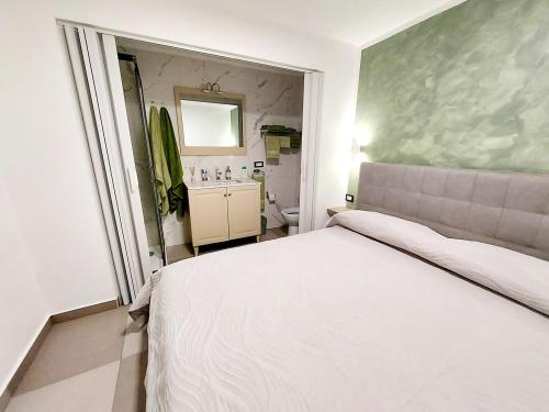 een slaapkamer met een wit bed en een badkamer bij Mi casa es tu casa in Napels
