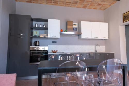 eine Küche mit einem Tisch und Stühlen sowie einem Kühlschrank in der Unterkunft Alla Torre - nel cuore del Borgo storico in Castagnole Lanze