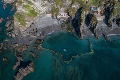 an aerial view of a beach with rocks and water at Chic Townhouse near Tunnels Beaches Ilfracombe in Ilfracombe