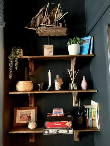 a book shelf with books and other items on it at Chic Townhouse near Tunnels Beaches Ilfracombe in Ilfracombe