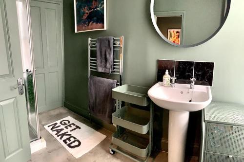 a bathroom with a sink and a mirror at Chic Townhouse near Tunnels Beaches Ilfracombe in Ilfracombe