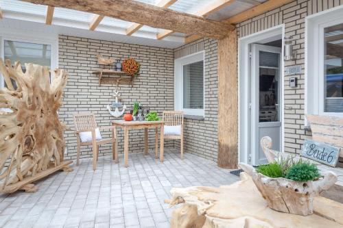 d'une terrasse avec une table et des chaises sur un mur en briques. dans l'établissement Die-Deichbude-1-Bude-6, à Büsum