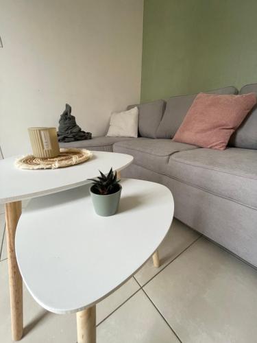 a living room with a couch and two tables at Le Pyrénéen - Le Bohème - Maison Cosy in Cazaubon