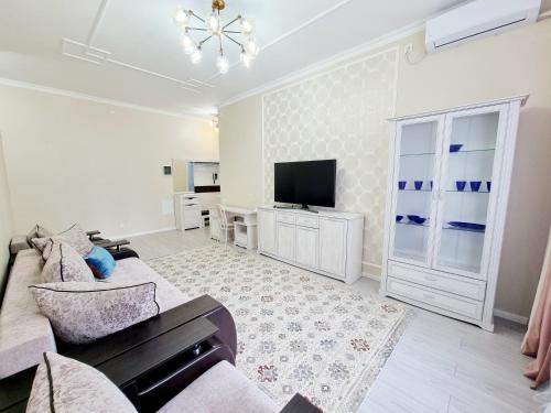 ein Wohnzimmer mit einem Sofa und einem Flachbild-TV in der Unterkunft Zaman in Atyrau