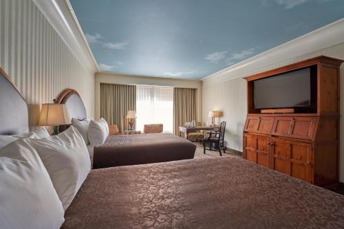 a hotel room with two beds and a flat screen tv at O.Henry Hotel in Greensboro