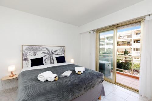 1 dormitorio con 1 cama grande y toallas. en Soleil 77 YourHostHelper, en Cannes