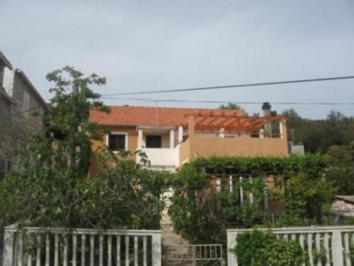 een huis met een wit hek ervoor bij Apartment Luca in Prvić Luka