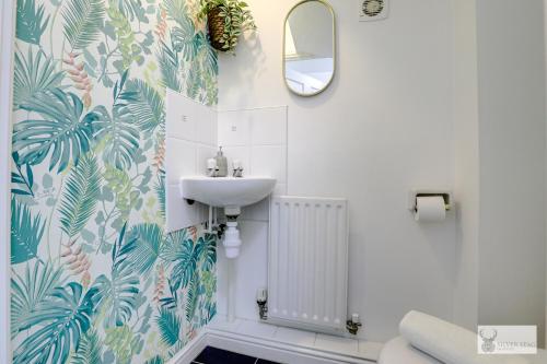 uma casa de banho com um lavatório e um espelho em Silver Stag Properties, Spacious 3 Story House em Whitwick