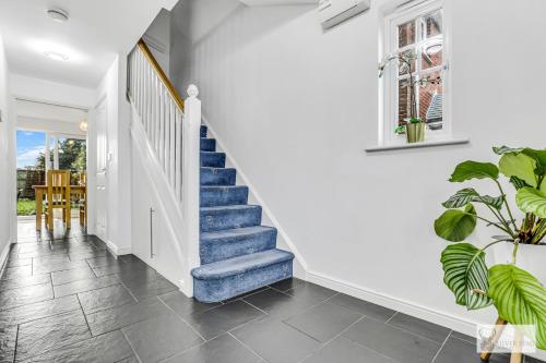 a staircase in a home with white walls and tile floors at Spacious Whitwick Stay 3-Story House in Whitwick