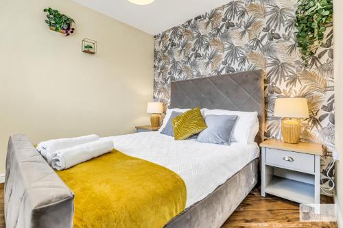 a bedroom with a bed with a yellow blanket on it at Spacious Whitwick Stay 3-Story House in Whitwick