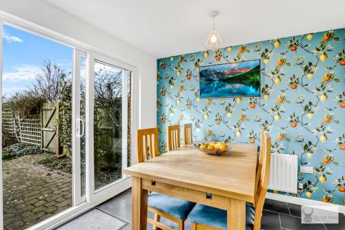 a dining room with a wooden table and chairs at Spacious Whitwick Stay 3-Story House in Whitwick