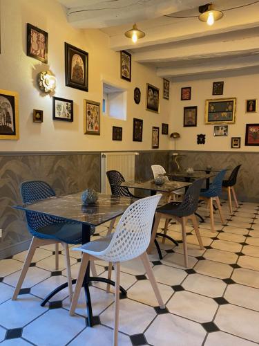 ein Restaurant mit Tischen und Stühlen und Bildern an der Wand in der Unterkunft Manoir De Rigourdaine in Plouër-sur-Rance