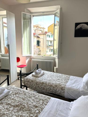 a hotel room with two beds and a window at Residenza La Libertà in Florence