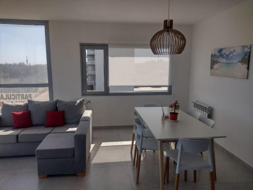 una sala de estar con un sofá y una mesa en Al Mar - Torres del Este, en Monte Hermoso