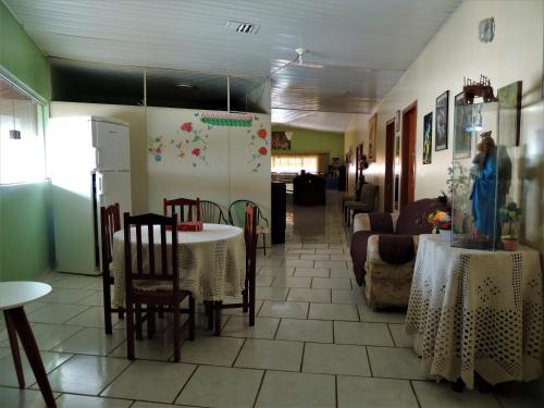 a dining room with a table and chairs and a room with a table at Pousada Santa Rita in Abadiânia