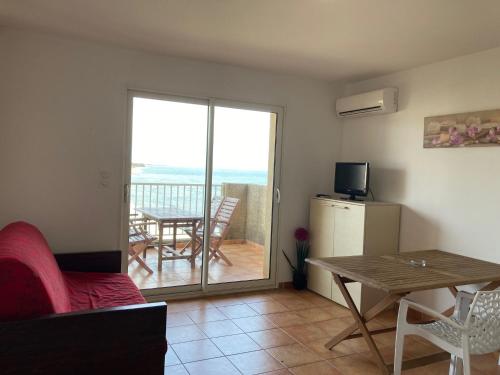 un soggiorno con divano e tavolo e un balcone di Punta di Mare a Linguizzetta