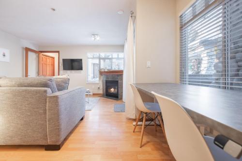 a living room with a couch and a table and a fireplace at Lagoons by Outpost Whistler in Whistler